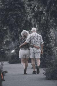 older veteran with arms around his wife walking away from the camera