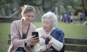 caregiver and elderly woman looking at phone